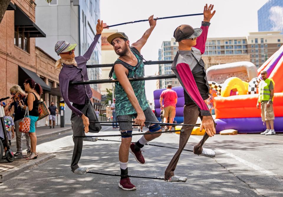 Antonio Nunez dances with puppets at Pecan Street Festival in 2019. In addition to art and street revelry, the long-running festival features free live music on three stages.