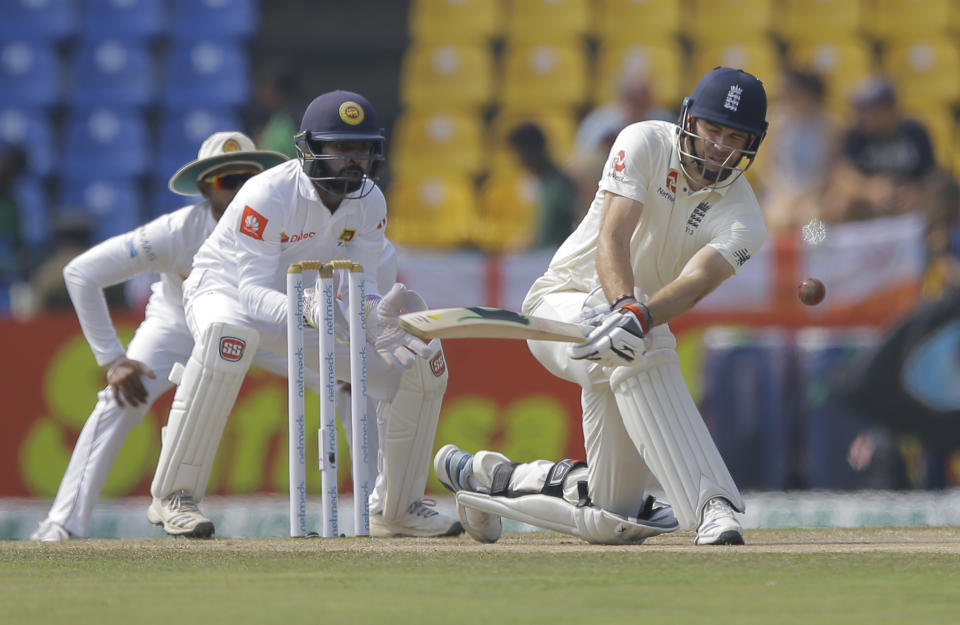 England's James Anderson plays a shot as Sri Lankan wicketkeeper Niroshan Dickwella watches during the fourth day of the second test cricket match between Sri Lanka and England in Pallekele, Sri Lanka, Saturday, Nov. 17, 2018. (AP Photo/Eranga Jayawardena)