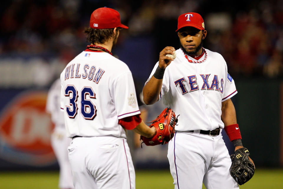 ARLINGTON, TX - OCTOBER 24: Elvis Andrus #1 of the Texas Rangers hands the ball to pitcher C.J. Wilson #36 during Game Five of the MLB World Series against the St. Louis Cardinals at Rangers Ballpark in Arlington on October 24, 2011 in Arlington, Texas. (Photo by Tom Pennington/Getty Images)