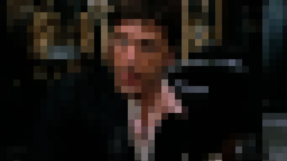 Al Pacino sits during a freak out in Scarface, pixelated.