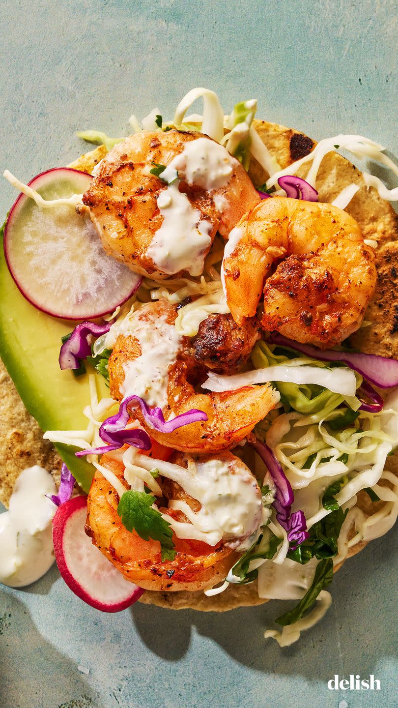 seasoned and seared shrimp topped with crisp cabbage slaw and creamy pickled jalapeno crema on a toasted corn tortilla