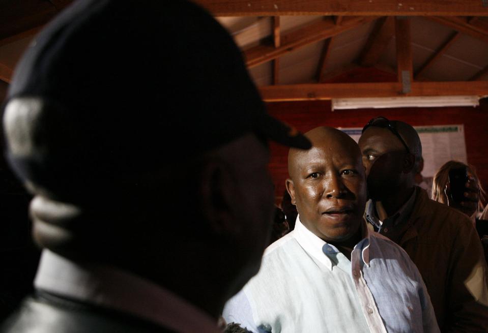 Expelled ruling party youth league president Julius Malema meets unidentified police official to lay murder charges against the police in Marikana near Rustenburg, South Africa, Tuesday, Aug. 21, 2012. Malema has lashed out at President Jacob Zuma and says the commission of inquiry into the Marikana shootings is politically motivated. Last Thursday 44 people have died in a wildcat strike, as South Africa urged the company to suspend an ultimatum to return to work. (AP Photo/Themba Hadebe)