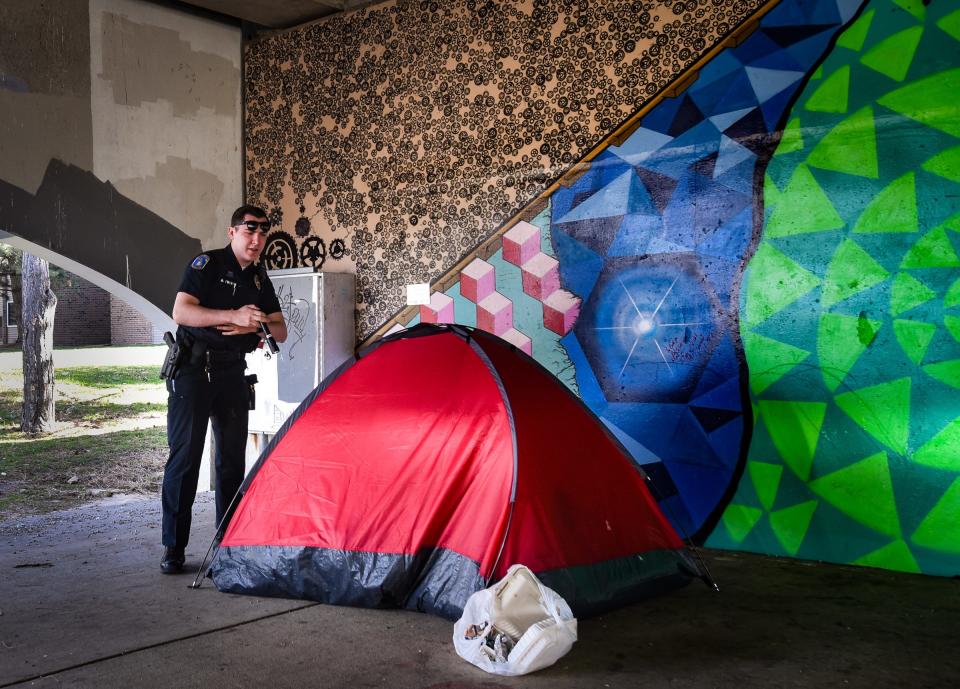 Lansing Police Dept. (LPD) Community Resource Officer (CRO) Damon Pulver stops for a welfare check Tuesday morning, April 11, 2023, after spotting this tent that had popped up below the Shiawassee Street Bridge since his previous patrol. As the CRO assigned to the downtown area, Pulver often works as a conduit connecting those within the community (often dealing with bouts of homelessness, mental health, and/or addiction issues) to one of the department's three full-time social workers.