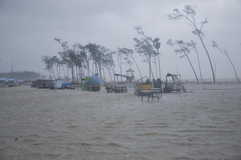 FILE- Beach vendors' kiosks are surrounded by water during high tide at the Digha beach on the Bay of Bengal coast as Cyclone Yaas intensifies in West Bengal state, India, Wednesday, May 26, 2021. India has yet to submit its targets for cutting greenhouse emissions to the U.N climate agency. Four months have passed since Indian Prime Minister Narendra Modi announced its 'net-zero' target and short-term goals for increasing clean energy. (AP Photo/Ashim Paul, file)