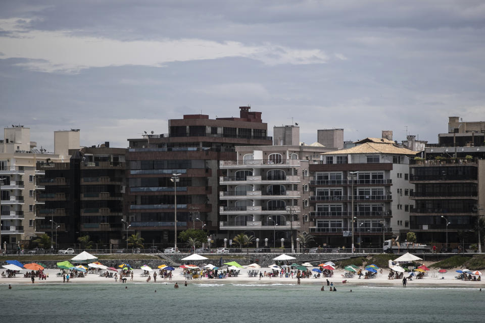 Beachgoers congregate on Fort Beach in Cabo Frio, Brazil, Wednesday, Dec. 15, 2021. As revenues rose for the cryptocurrency investment firm G.A.S Consulting & Technology, enriching some early adopters, copycat firms sprang up, seeking to cash in on the craze. Cabo Frio, the home of G.A.S. founder, 38-year-old Glaidson Acacio dos Santos, came to be known as the “New Egypt” and as the town’s top dog, dos Santos was the “Bitcoin Pharaoh." (AP Photo/Bruna Prado)