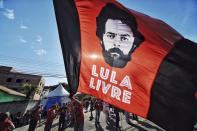 FILE - A supporter of former President Luiz Inacio Lula da Silva holds a flag that reads in Portuguese: "Free Lula," in front of the Federal Police Department where Da Silva is serving jail time in Curitiba, Brazil, July 8, 2018. With his convictions annulled in March of 2021, Da Silva, known universally as Lula, was cleared for a presidential run. (AP Photo/Denis Ferreira Netto, File)