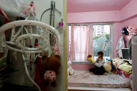 Manman Luk, a freelance model and make up artist, poses inside her 100-square-foot (9-square-metre) sub-divided unit, paying a monthly rent of HK4,700 ($606) in Hong Kong, China January 6, 2017. REUTERS/Bobby Yip
