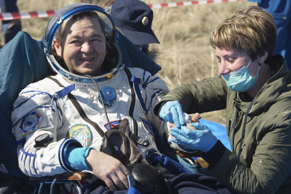 In this handout photo released by Gagarin Cosmonaut Training Centre (GCTC), Roscosmos space agency, Russian cosmonaut Oleg Skripochka gets assistance shortly after the landing of the Russian Soyuz MS-15 space capsule near Kazakh town of Dzhezkazgan, Kazakhstan, Friday, April 17, 2020. An International Space Station crew has landed safely after more than 200 days in space. The Soyuz capsule carrying NASA astronauts Andrew Morgan, Jessica Meir and Russian space agency Roscosmos' Oleg Skripochka touched down on Friday on the steppes of Kazakhstan. (Andrey Shelepin, Gagarin Cosmonaut Training Centre (GCTC), Roscosmos space agency, via AP)