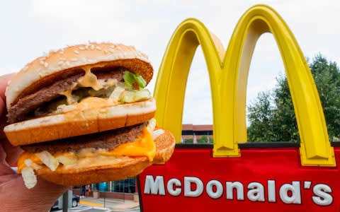 McDonald's Big Mac, held up near the golden arches at a McDonald's restaurant  - Credit: PAUL J. RICHARDS/AFP