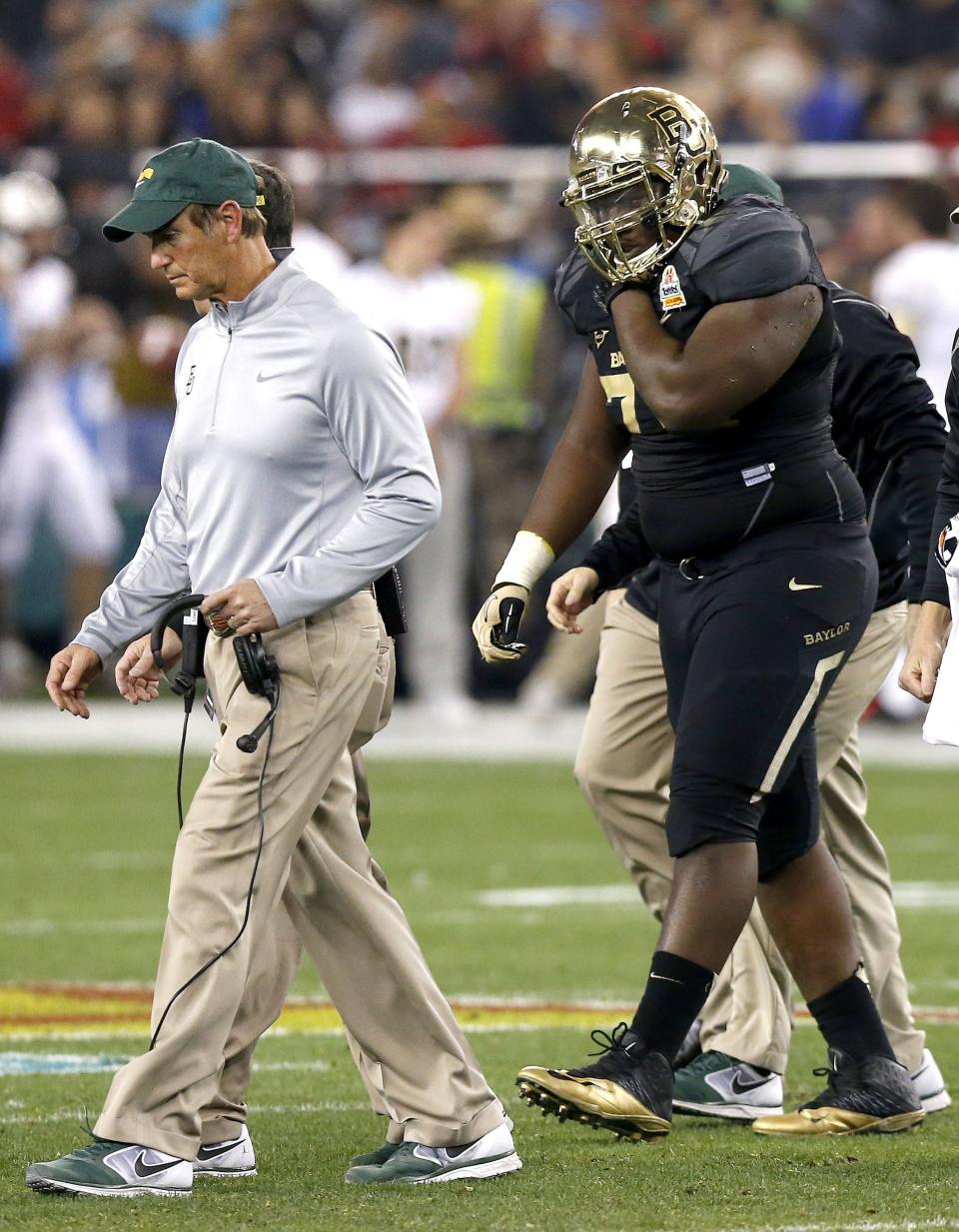 Baylor's Andrew Billings, right, leaves the field holding his right shoulder as coach Art Briles, left, walks off with him during the first half of the Fiesta Bowl NCAA college football game against Central Florida on Wednesday, Jan. 1, 2014, in Glendale, Ariz. (AP Photo/Ross D. Franklin)