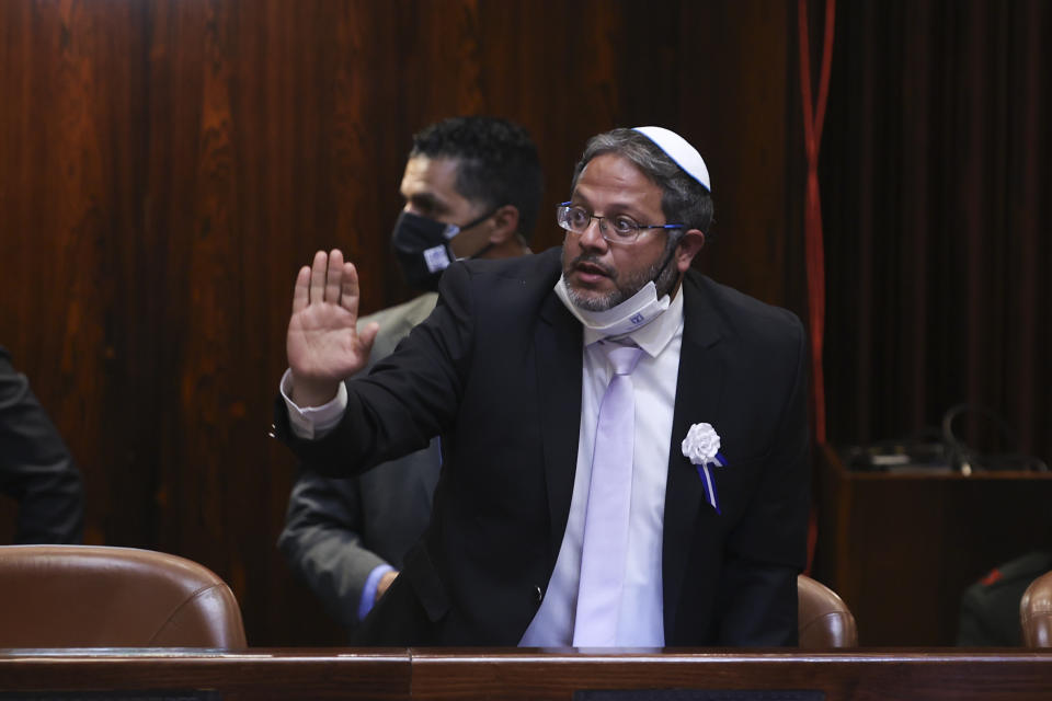 Newly elected Israeli Knesset members and Itamar Ben-Gvir, a member from the Religious Zionist party, center, attend the swearing-in ceremony for Israel's 24th government, at the Knesset, or parliament, in Jerusalem, Tuesday, April 6, 2021. The ceremony took place shortly after the country's president asked Prime Minister Benjamin Netanyahu to form a new majority coalition, a difficult task given the deep divisions in the fragmented parliament. (Alex Kolomoisky/Pool via AP)