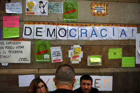 Students inform a man where he can vote in the banned October 1 independence referendum, outside the University of Barcelona in Barcelona, Spain, September 25, 2017. REUTERS/Jon Nazca