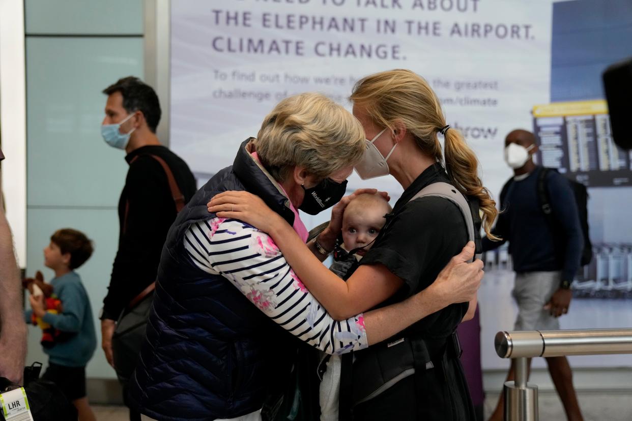 Susan Handfield meets her baby granddaughter Charlotta, held by her mother, Eva, at London's Heathrow Airport on Aug. 2, 2021, after the U.K. relaxed travel restrictions for visitors from the U.S. and European Union.