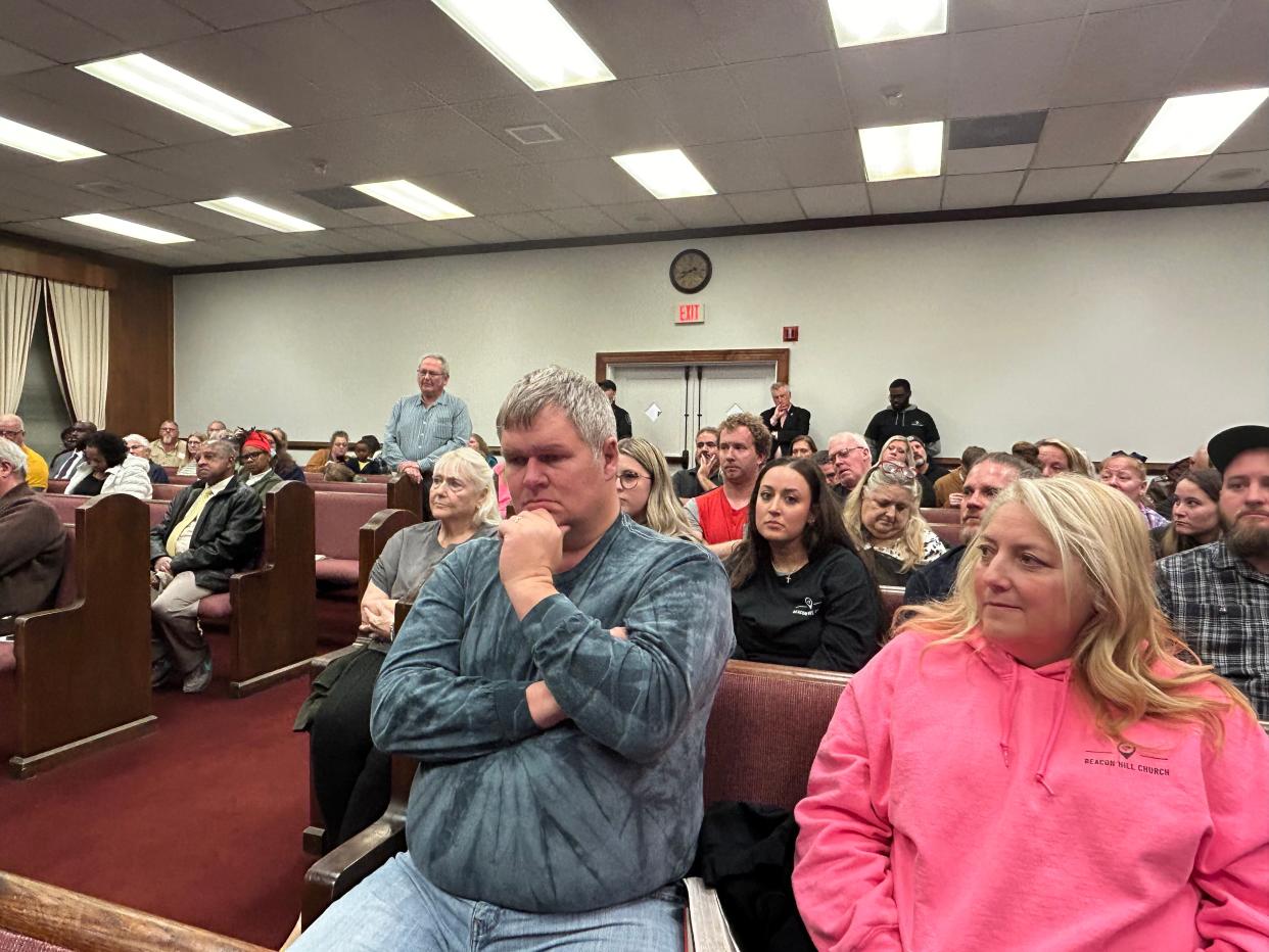 Michael Moore, left, and his wife, Kim, listen to comments on behalf of ‘Free Food Friday,’ a weekly giveaway sponsored by Beacon Hill Church, during the Hopewell City Council meeting Tuesday, Feb. 13, 2024. Michael Moore is Beacon Hill’s pastor.