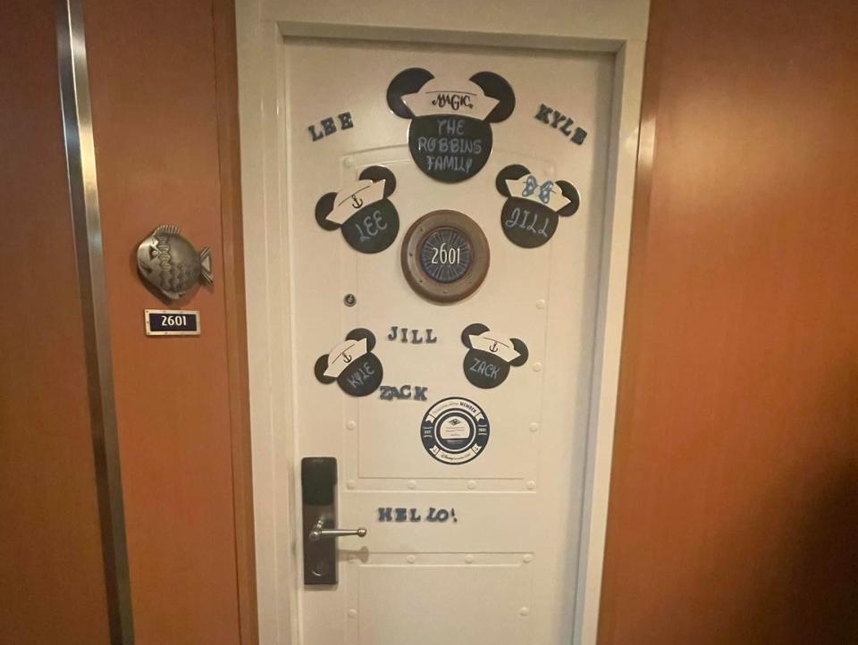 door of a disney cruise stateroom decorated with nametags