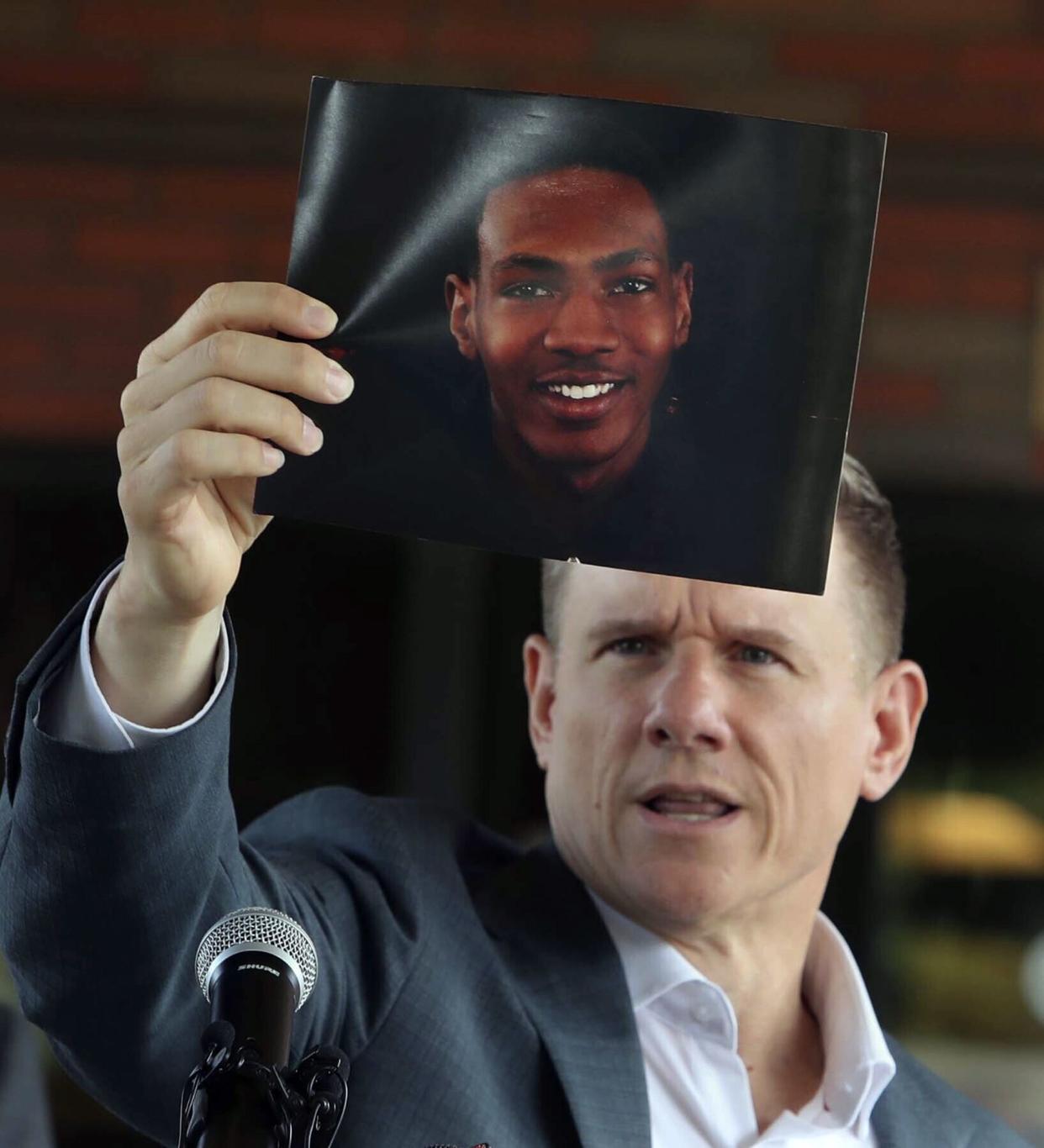 Attorney Bobby DiCello, representing the family of Jayland Walker, holds up a photograph of Walker before a press conference on Sunday.