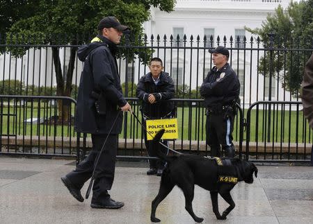 U.S. Park Police stand along the sidewalk on Pennsylvania Ave at a new layer of temporary fencing that appeared this week creating a wider buffer along the sidewalk in front of the White House in Washington in this September 25, 2014, file photo. REUTERS/Larry Downing/Files