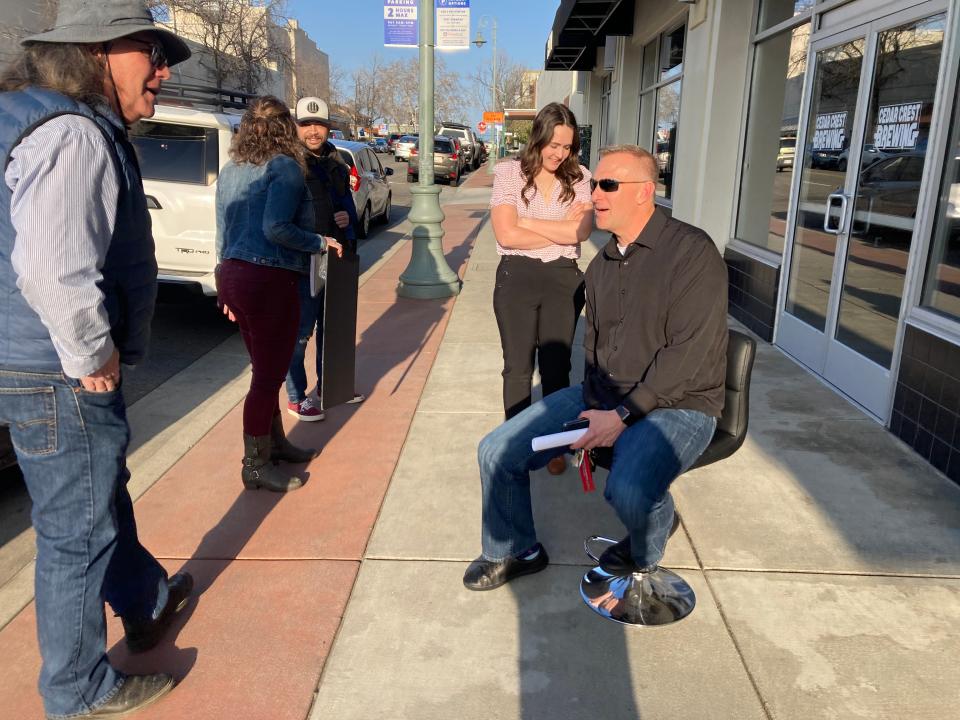 Shasta County District 1 Supervisor Kevin Crye, seated, talks to Christian Gardinier before Crye's town hall on Thursday, March 16, 2023 in downtown Redding.