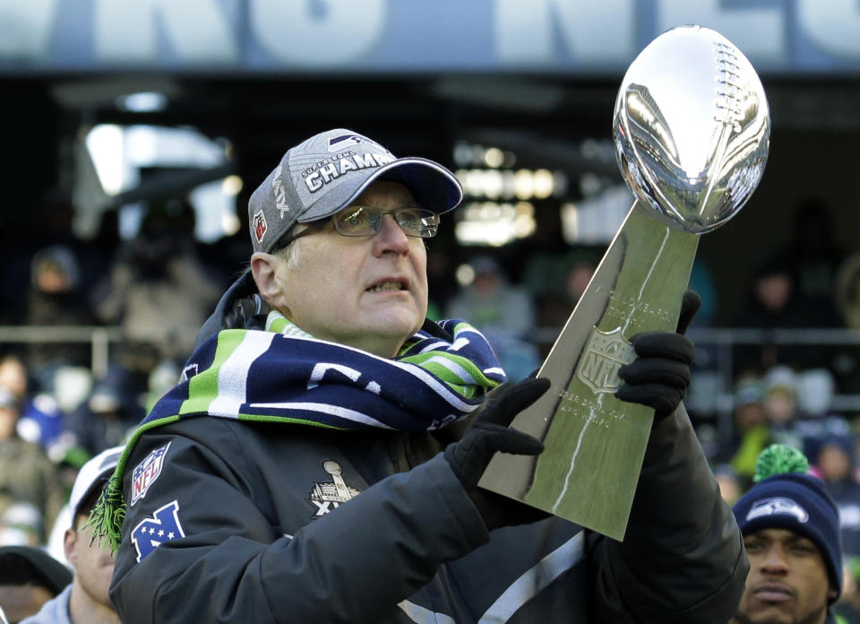 ARCHIVO - En esta foto de archivo del 5 de febrero de 2014, Paul Allen, dueño de los Seahawks de Seattle, sostiene el trofeo Vince Lombardi conquistado por el equipo, durante una celebración en el CenturyLink Field (AP Foto/Ted S. Warren, archivo)