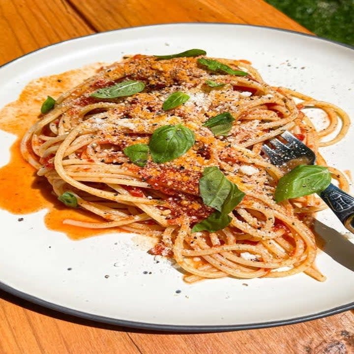 marinara sauce over spaghetti with basil on a plate