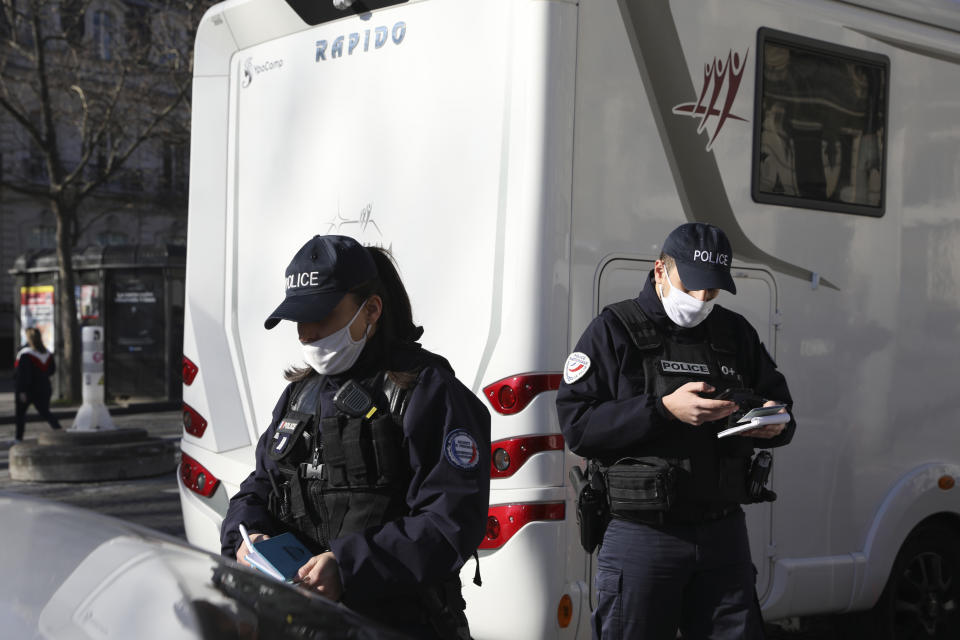 Police officers check a camper van on the Champs-Elysees avenue, Saturday, Feb.12, 2022 in Paris. Paris police intercepted at least 500 vehicles attempting to enter the French capital in defiance of a police order to take part in protests against virus restrictions inspired by the Canada's horn-honking "Freedom Convoy." The police said that several convoys were stopped from entering at key city arteries and over 200 motorists were handed tickets -- amid a huge weekend mobilization of some 7,000 officers(AP Photo/Adrienne Surprenant)