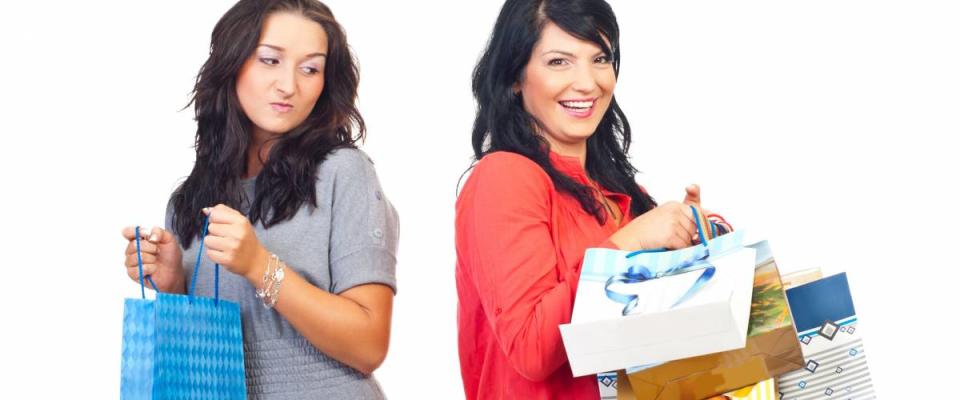 Envious woman on her friend with many shopping bags isolated on white background