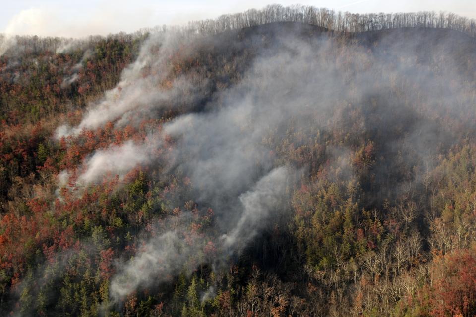 FILE - Wildfires burn near Gatlinburg, Tenn., on Nov. 29, 2016. A new study finds that climate change is making droughts faster and more furious — and especially one fast-moving kind of drought that can take farmers by surprise. (AP Photo/Wade Payne, File)