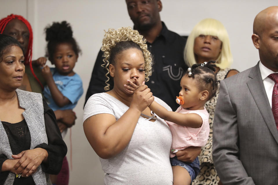 Tomika Miller, the wife of Rayshard Brooks, holds their daughter during a press conference