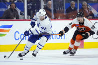 Toronto Maple Leafs' Morgan Rielly, left, tries to keep the puck away from Philadelphia Flyers' Joel Farabee during the second period of an NHL hockey game, Thursday, March 14, 2024, in Philadelphia. (AP Photo/Matt Slocum)