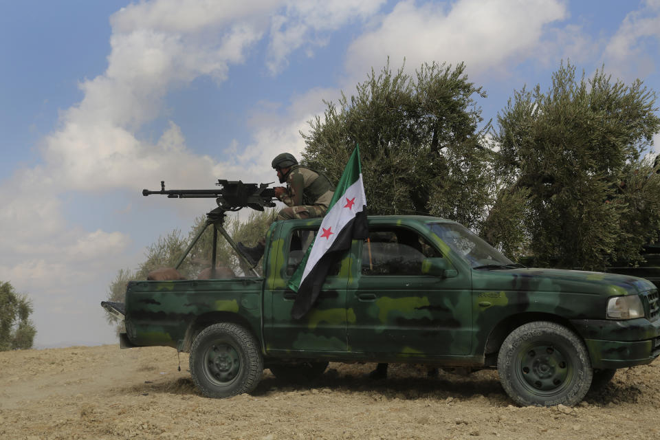 In this Monday Oct. 7, 2019 photo, a fighter from the Turkish-backed Free Syrian Army, fires a heavy machine gun during military training maneuvers in preparation for an anticipated Turkish incursion targeting Syrian Kurdish fighters, near Azaz, in north Syria. Turkey's vice president said Tuesday his country won't bow to threats in an apparent response to U.S. President Donald Trump who warned Ankara about the scope of its planned military incursion into northeast Syria. (AP Photo)