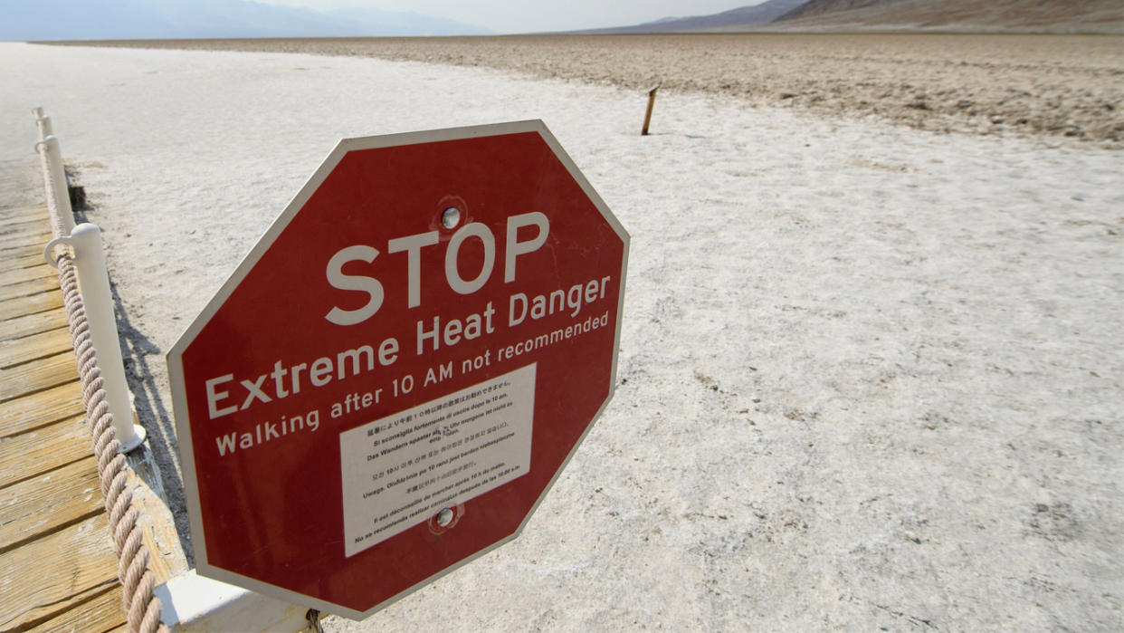 Signage warns of extreme heat danger at the salt flats of Badwater Basin inside Death Valley National Park on June 17, 2021 in Inyo County, California. (Patrick T. Fallon/AFP via Getty Images)