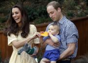 Britain's Kate, the Duchess of Cambridge, and her husband Prince William react as their son Prince George bites a small present that was given to him during a visit to Sydney's Taronga Zoo, Australia Sunday, April 20, 2014. (AP Photo/David Gray, Pool)