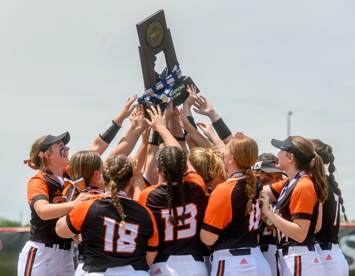 The Illini Bluffs Tigers reach out to touch their Class 1A state softball championship trophy after defeating Casey-Westfield 1-0 in nine innings Saturday, June 4, 2022 at the Louisville Slugger Sports Complex in Peoria. The Tigers defended their 2022 title with a walk-off RBI from junior Lilly Hicks and a one-hit performance from senior pitcher Kierston McCoy.