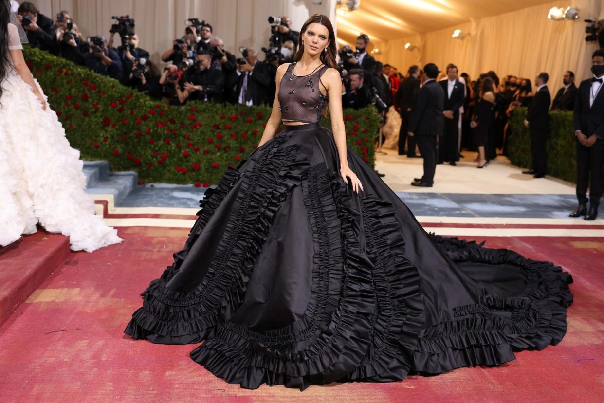 Kendall Jenner attends the 2022 Met Gala in a black dress with a giant skirt and mesh top.