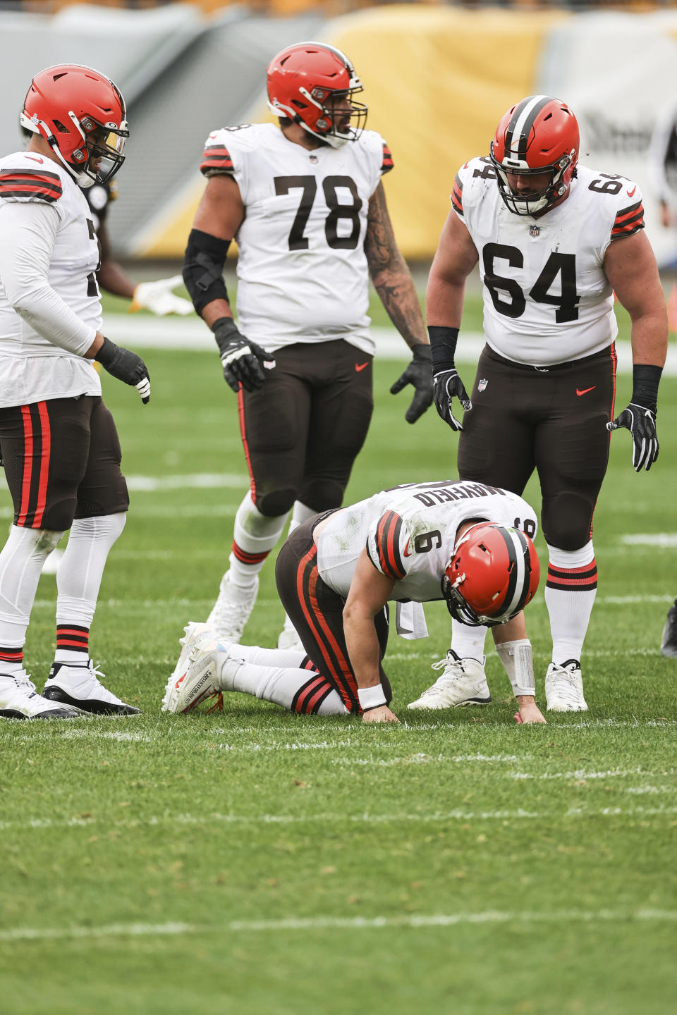 Cleveland Browns quarterback Baker Mayfield (6) tries to recover from a sack as teammates offensive tackle Jedrick Wills (71), offensive tackle Jack Conklin (78) and center JC Tretter (64) look on during an NFL game against the Pittsburgh Steelers, Sunday, Oct. 18, 2020, in Pittsburgh. The Steelers defeated the Browns 38-7. (Margaret Bowles via AP)