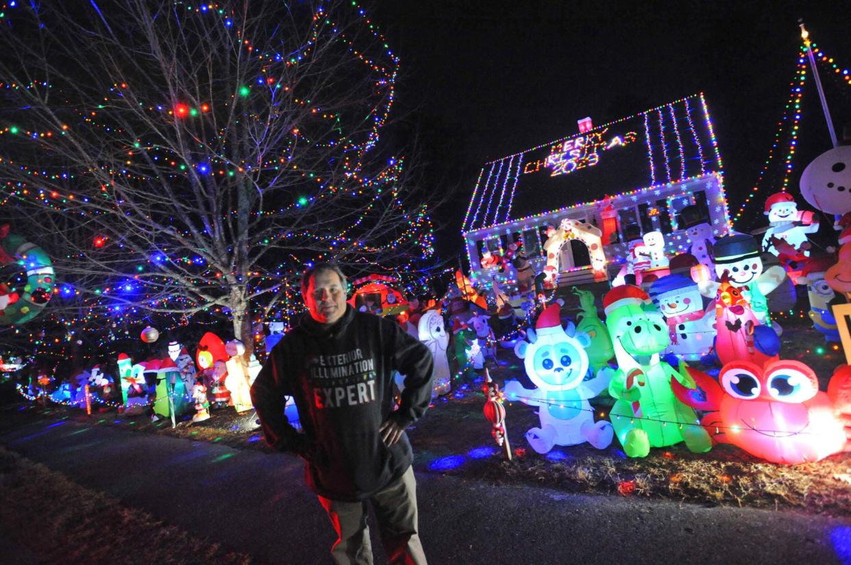 Tim Young stands in front of his Hanson home, which includes over 150 inflatable figures.