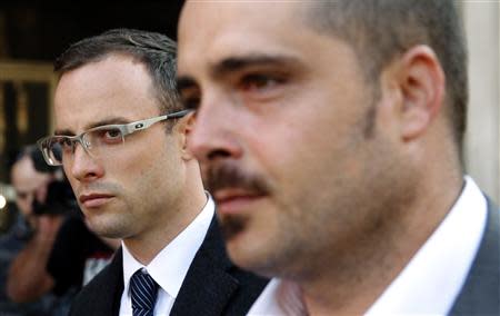 South African Olympic and Paralympic track star Oscar Pistorius (L) arrives to attend his trial at the high court in Pretoria April 8, 2014. REUTERS/Siphiwe Sibeko