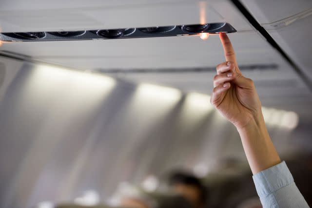 <p>Getty</p> Stock image of a person turning on a light inside a plane