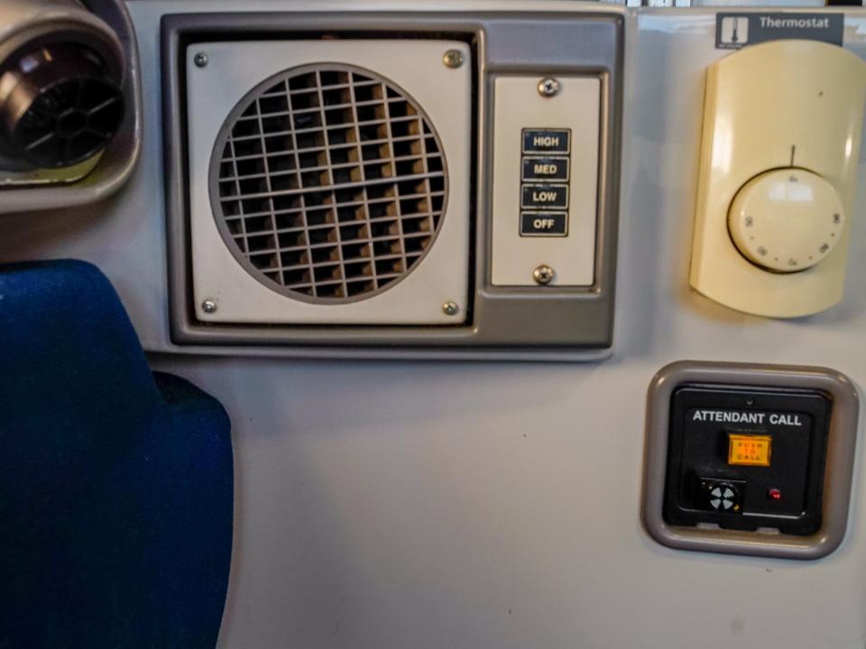 A close up of the thermometer, air conditioning, and attendant call button