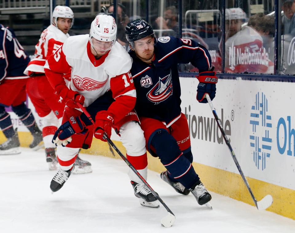 Detroit Red Wings forward Jakub Vrana, left, controls the puck in front of Columbus Blue Jackets forward Jack Roslovic during the first period of an NHL hockey game on Saturday, May 8, 2021.