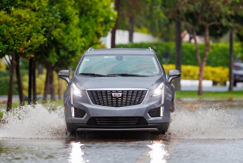 A car goes through the flooded road cause by heavy rains at North Bay Rd in Sunny Isles Beach on Wednesday, April 25, 2023.