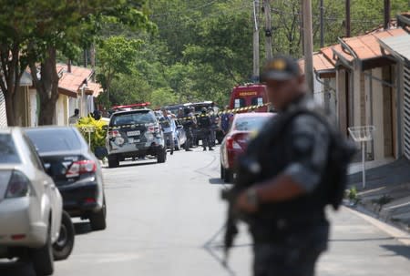 A police officer is seen near a site where an armed gang holds people hostage after they robbed a securities company at the Viracopos airpoart freight terminal, in Campinas