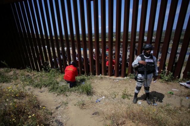 FILE PHOTO: Migrants gather along the U.S. Mexico border before the lifting of Title 42, as seen from Tijuana