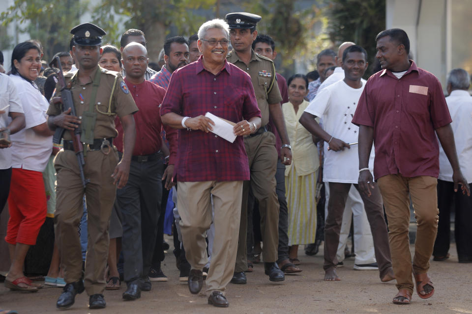 Sri Lanka's former Defense Secretary and presidential candidate Gotabaya Rajapaksa, center, leaves a polling station after casting his vote in Embuldeniya, on the outskirts of Colombo, Sri Lanka, Saturday, Nov. 16, 2019. Polls opened in Sri Lanka’s presidential election Saturday after weeks of campaigning that largely focused on national security and religious extremism in the backdrop of the deadly Islamic State-inspired suicide bomb attacks on Easter Sunday. (AP Photo/Eranga Jayawardena)