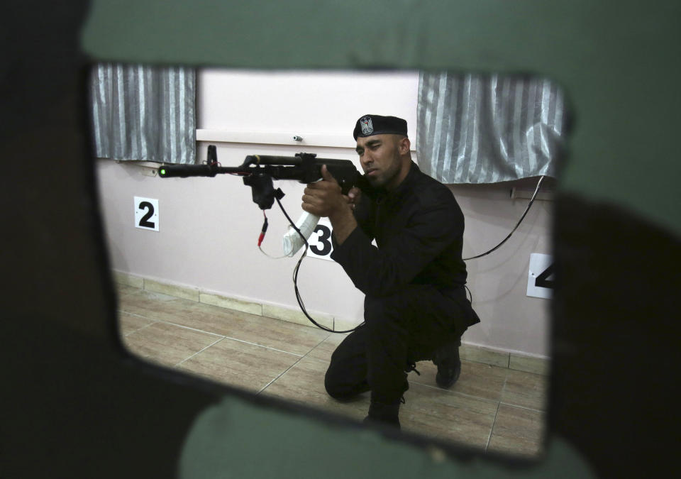 Palestinian security officer Ahed Abu Shabban, 23, aims an electronically-modified AK-47 rifle at the headquarters of the security training department of the Hamas interior ministry in Gaza City, in the northern Gaza Strip on Thursday, April 10, 2014. Adnan Abu Amer, an expert on Palestinian militant groups at Gaza's Al Ummah University, says the prices of some weapons have nearly doubled in recent months, and the price of ammunition has tripled. "The most significant result of the tunnel demolitions has been the scarcity of weapons, ammunition and explosives," he says. (AP Photo/Adel Hana)