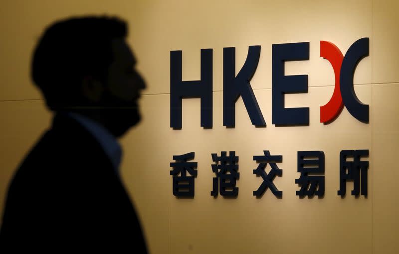 A man walks past the entrance to the Hong Kong Exchanges bearing a new logo in Hong Kong