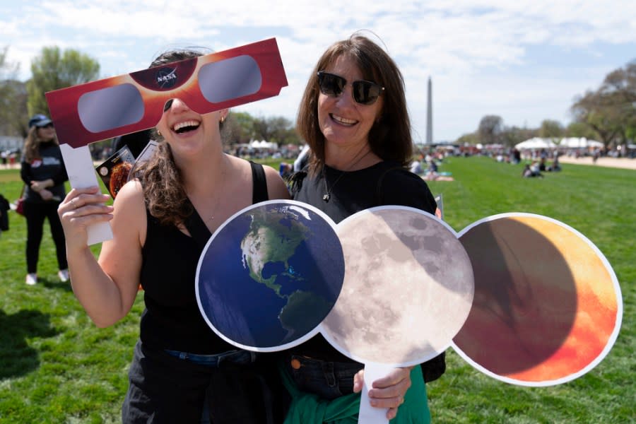 Mackenzie Trumbull, left, and Kathy Trumbull pose for a picture as they gather to watch as the moon partially covers the sun during a total solar eclipse, as seen from at National Mall in Washington, Monday, April 8, 2024. (AP Photo/Jose Luis Magana)