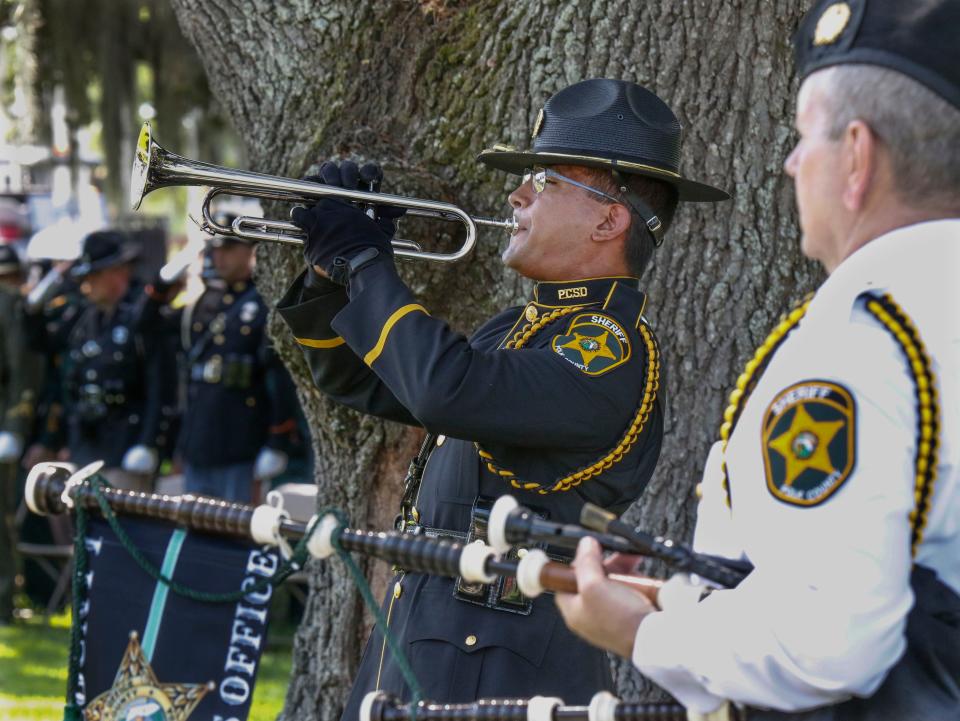 A Polk County sheriff's honor guard member plays Taps near the end of the Peace Officer Memorial service at Veterans Memorial Park in Lakeland on Thursday.