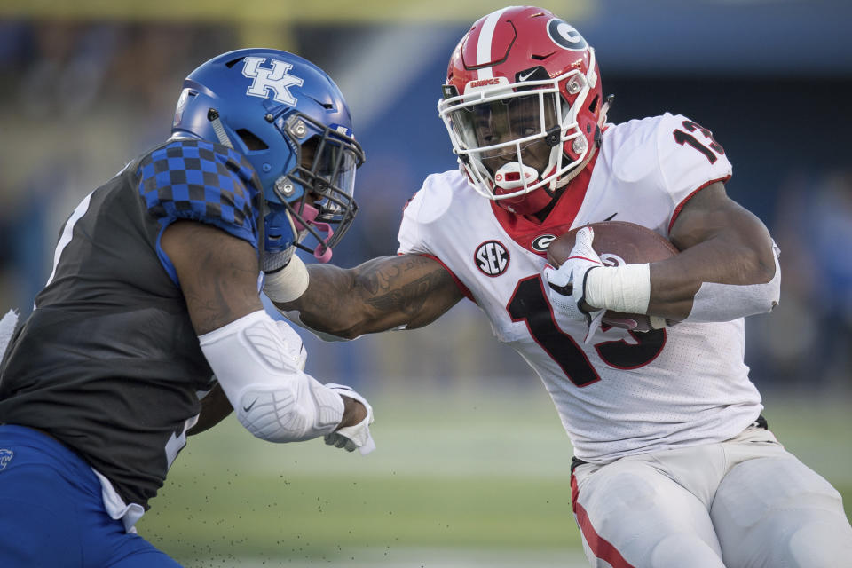 Georgia running back Elijah Holyfield (13) stiff arms Kentucky safety Mike Edwards (7) during the second half an NCAA college football game in Lexington, Ky., Saturday, Nov. 3, 2018. (AP Photo/Bryan Woolston)