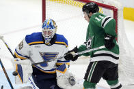 St. Louis Blues goaltender Jordan Binnington (50) deflects a shot with his arm pad under pressure from Dallas Stars center Logan Stankoven (11) during the second period of an NHL hockey game in Dallas, Wednesday, April 17, 2024. (AP Photo/Tony Gutierrez)